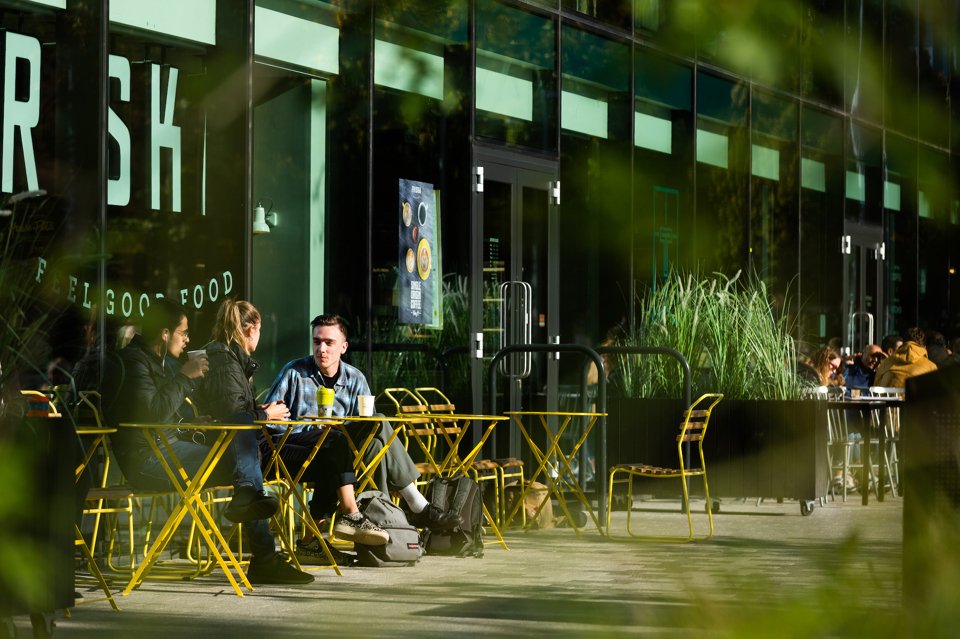 Group of people sat at a table outside of a cafe