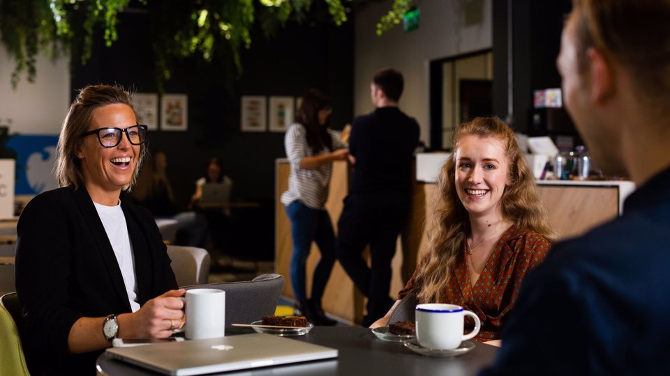 Small group of people sat at a table in a coffee shop