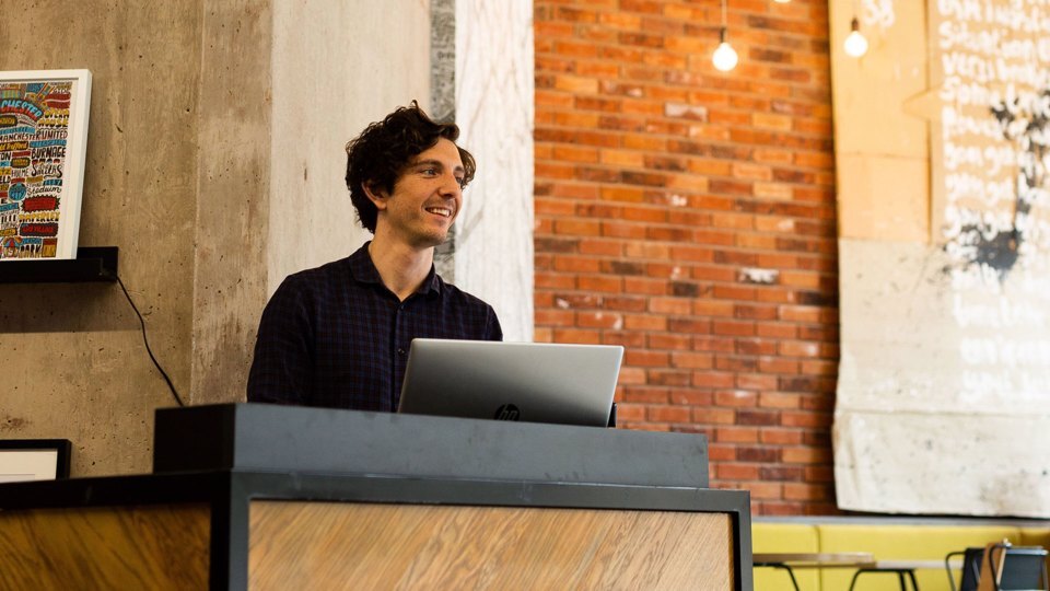 Host stood at a speaker stand at an event