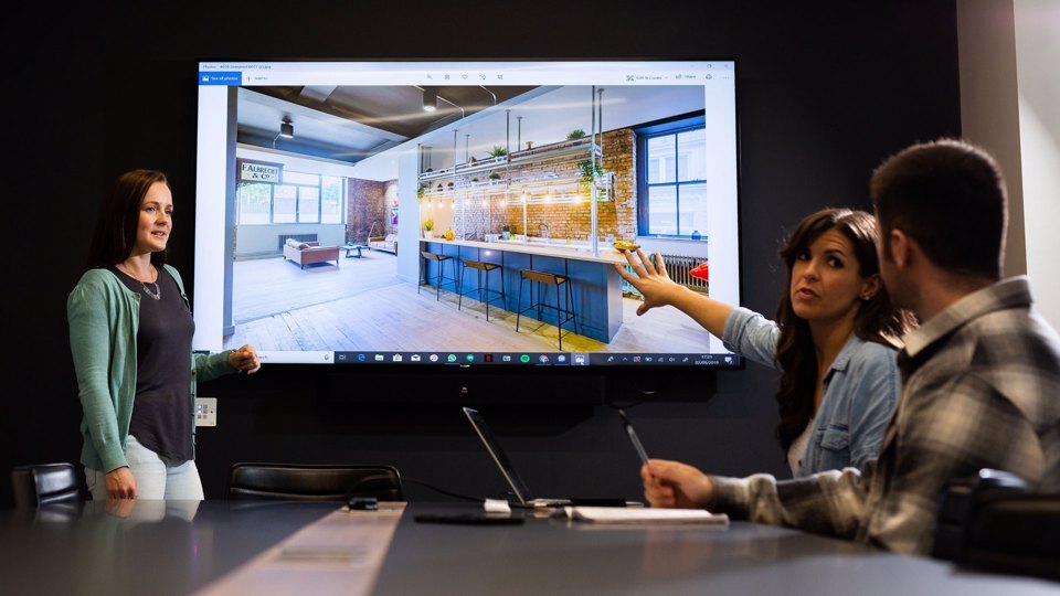 Group of people collaborating at a meeting in front of a smartboard