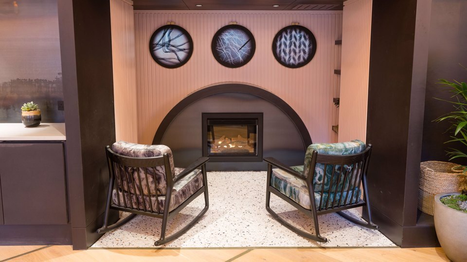 2 rocking chairs in front of a fireplace in a breakout space