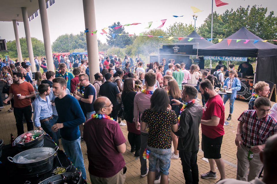 Groups of people gathered and socialising at a barbeque