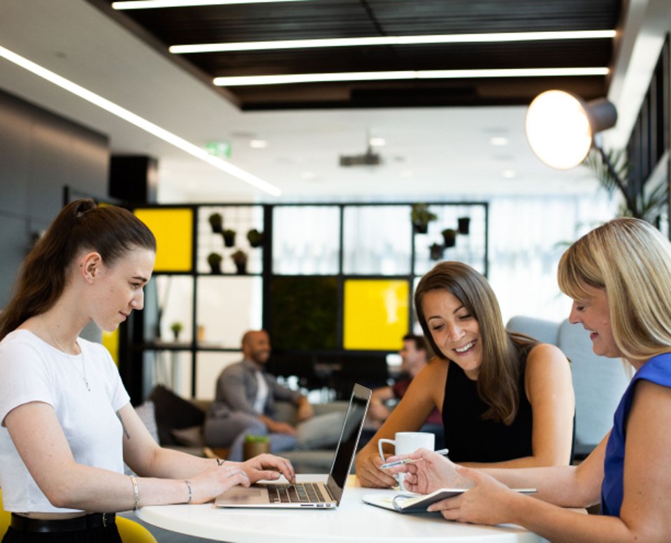 3 people working together at a table in an openspace