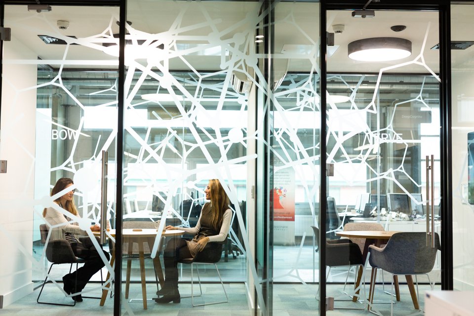 2 people sat a desk collaborating in an office