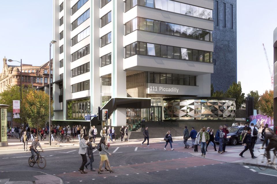 Outside view of the 111 piccadilly building with large crowds of people crossing a road.