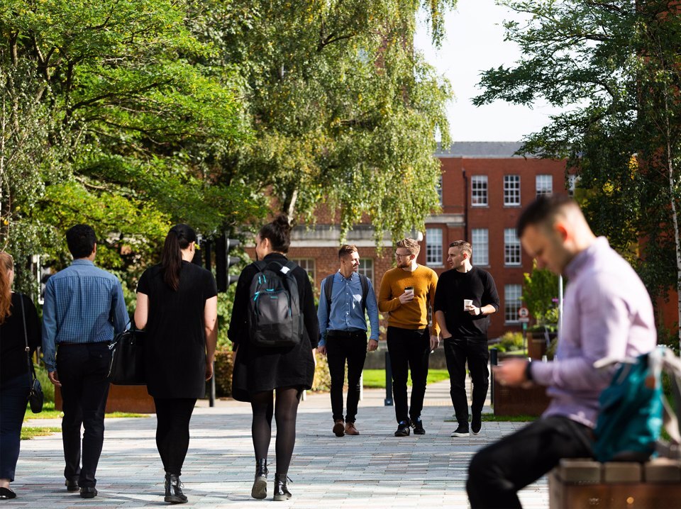 People walking around a tree lined path at Birmingham Health Innovation Campus