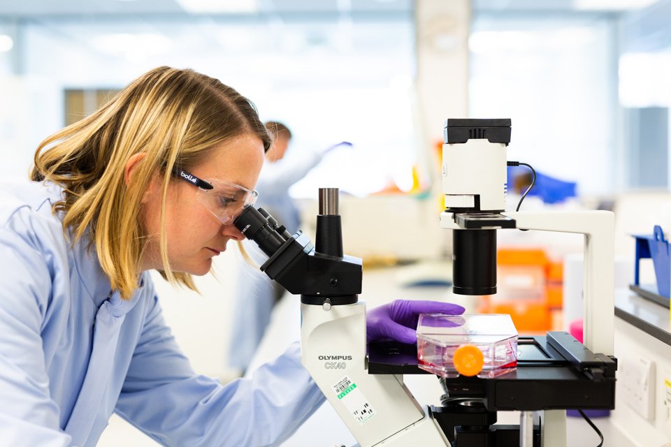 Scientist looking into a microscope