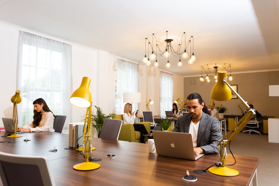 Group of people sat separately and working in office space