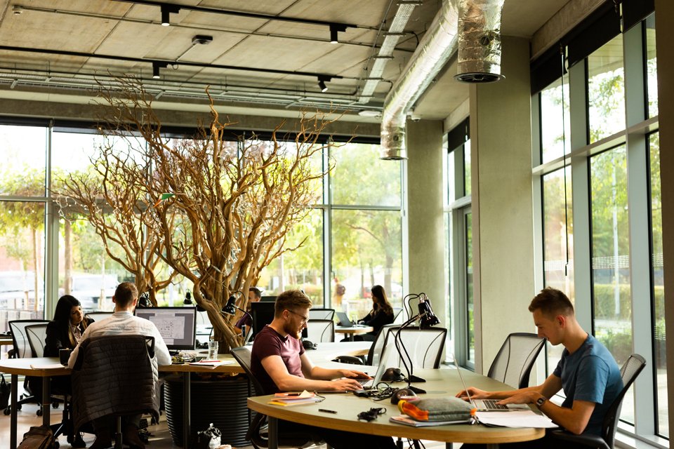 An openspace consisting of multiple groups each sat at their own tables collaborating