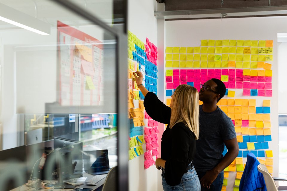 Two people collaborating at wall of post it's in a Bruntwood office