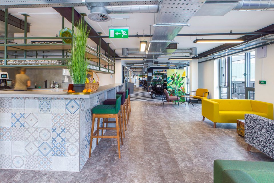 Wide and spacious kitchen area with brightly coloured furniture.