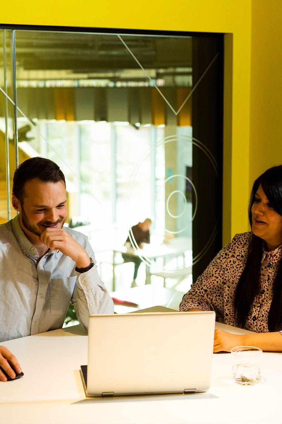 2 people sat working together in a meeting room at Manchester Science Park